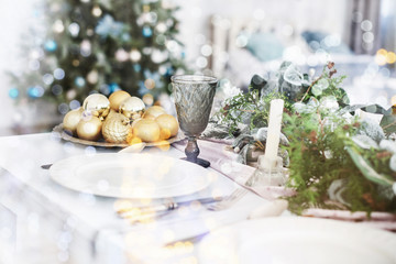 Table served for Christmas dinner in living room, close up view. Bokeh light soft effect