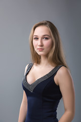 Fototapeta premium young woman with long blonde hair. Studio portrait on a gray background.