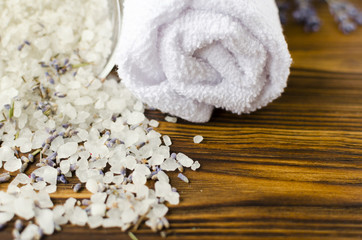 Obraz na płótnie Canvas towel and sea salt with lavender on wooden table. spa treatment