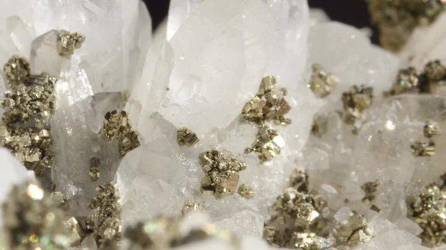 MACRO DOF: White quartz with metallic pyrite particles shining like ice under bright lights. Glimmering opaque quartz with metallic pyrite creating a beautiful image. Lavish precious stones glittering