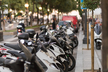 Several bikes parked on a motorcycle parking lot on the street