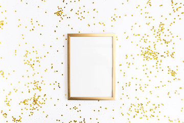 Photo frame mock up with space for text, golden confetti on white background. Lay Flat, top view....