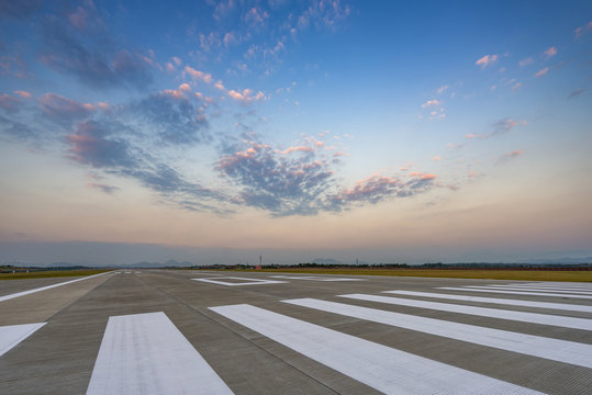 Runway, airstrip in the airport terminal with marking on blue sky with clouds background. Travel aviation concept.