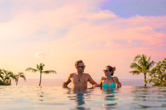 Couple relaxing in infinity pool of exotic luxury resort