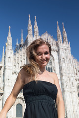 Beautiful happy girl in black dress over the famous Duomo Cathedral in Milan, Italy