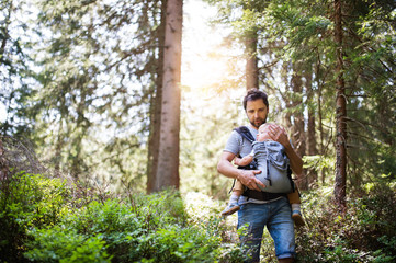 Naklejka na ściany i meble Young father with little boy in forest, summer day.