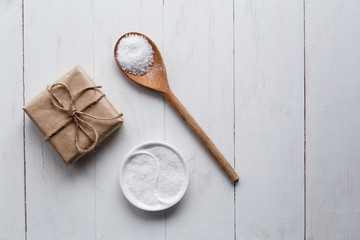 Healthy Sea Salt with giftbox on white wooden background. Flat lay. Copy space.