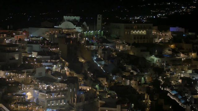 SANTORINI, GREECE – AUGUST 2016 : Video shot of Santorini cityscape at night with traditional white buildings and swimming pool in view