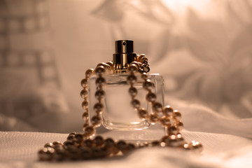 Women perfume bottle and pearl necklace