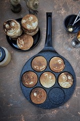 In the kitchen in a frying pan pancakes, fritters with smileys. View from above