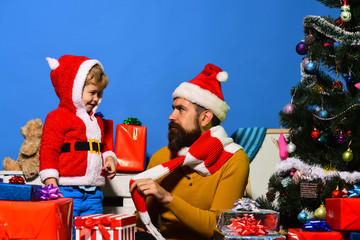 Man with beard and serious face plays with son.