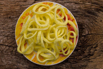 Plate with crispy snacks onion rings on wooden table