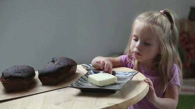Cute little girl leak butter from sandwich. Child eating bread and and butter