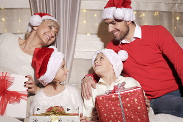 Rodzina na kanapie z prezentami podczas Świąt Bożego Narodzenia