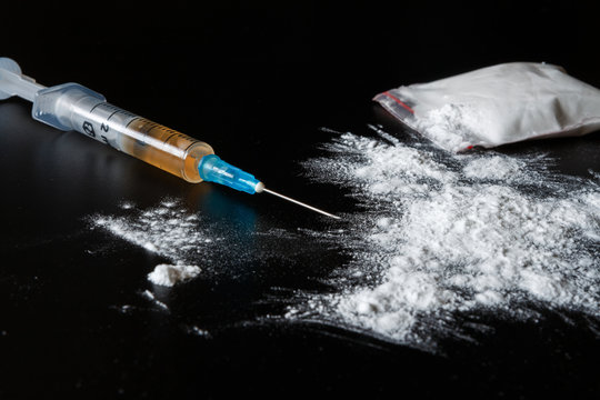 Drug heroin, syringes, money on a dark background with copy space, concept of crime and addiction