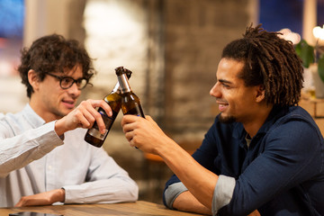 happy male friends drinking beer at bar or pub
