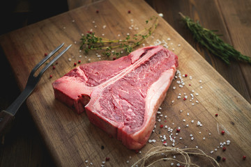 uncooked t bone steak of beef on the butcher's Board