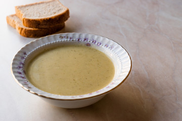Broccoli Soup with Bread on Ceramic Surface.