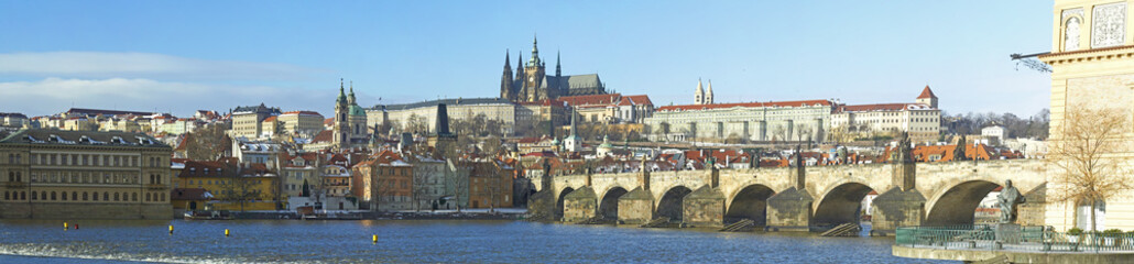 Fototapeta na wymiar A panoramic view of the Prague Castle, Vltava river and the Charles Bridge. Unidentified tourists admiring the famous city