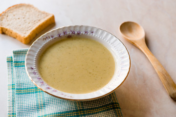 Broccoli Soup with Bread on Ceramic Surface.