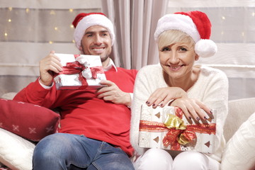 Boże Narodzenie. Rodzina na kanapie z prezentami.