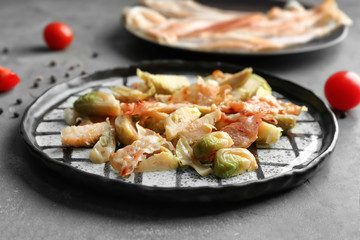 Plate with roasted Brussel sprouts and bacon on table