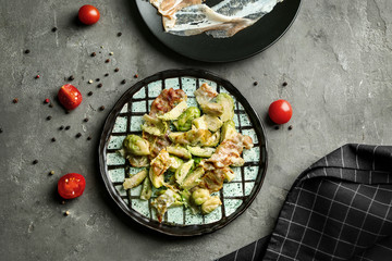 Plate with roasted Brussel sprouts and bacon on table