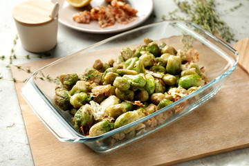 Baking dish with roasted Brussel sprouts and bacon on table