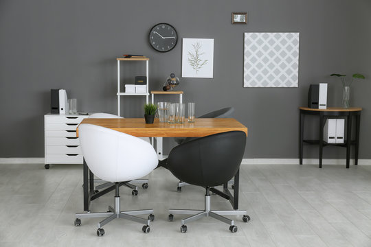 Modern office interior with black and white armchairs