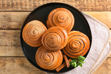 Plate with sweet cinnamon rolls on table