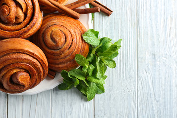 Plate with tasty cinnamon buns on table