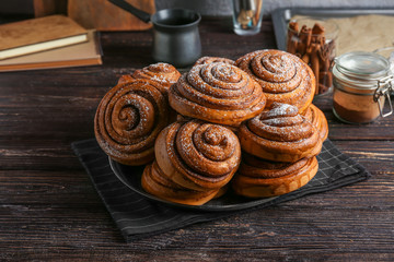 Plate with tasty cinnamon buns on table