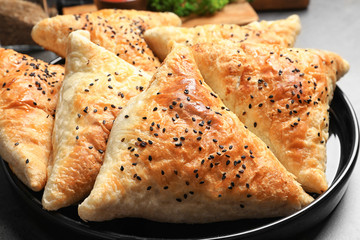 Plate with delicious samosas on table, closeup