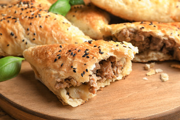 Delicious meat samosa on wooden board, closeup