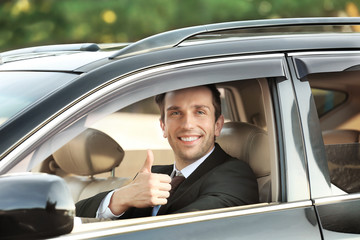 Fototapeta na wymiar Businessman in driver's seat of car