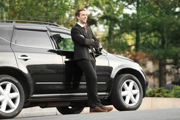 Fototapeta na wymiar Man in formal wear standing near car outdoors