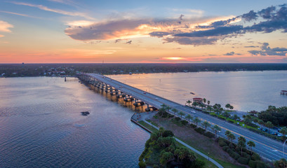 An overhead view of a bridge over water at sunset