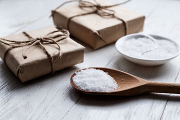 sea salt on wooden background with gift boxes