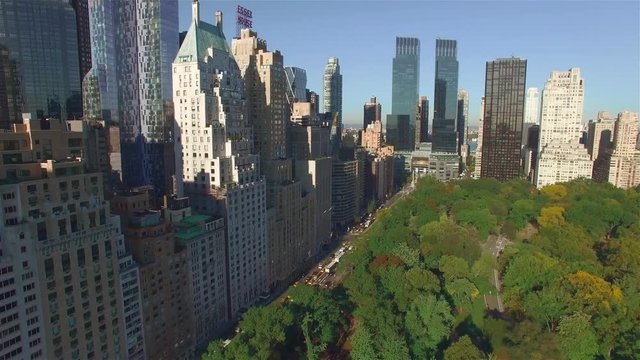 Aerial real time shot, camera is flying above Central Park along West 95th Street in New York.