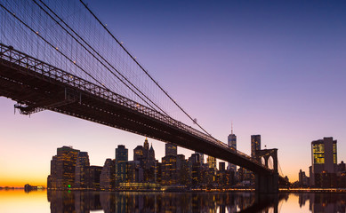New York City Panoramic landscape view of Manhattan with famous Brooklyn Bridge at sunset.