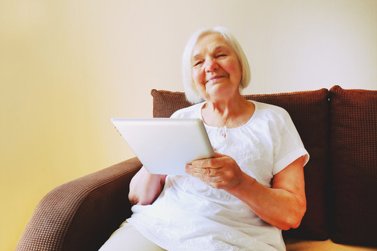 Portrait of  beautiful smiling senior woman using ipad.