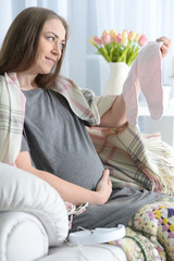 beautiful pregnant woman sitting in armchair 