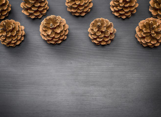 brown pine cones on a black wooden background