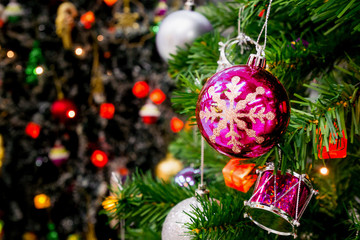 Decorated Christmas tree with colorful bauble on sparkling bokeh light blurred background