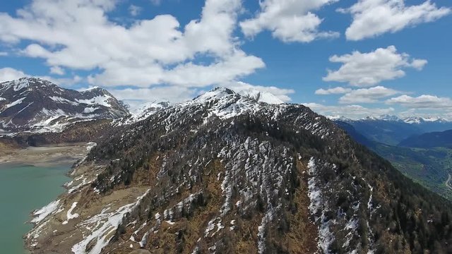 Aerial view on Ritom lake between snow-capped mountains at spring, Switzerland alps, panorama 4k
