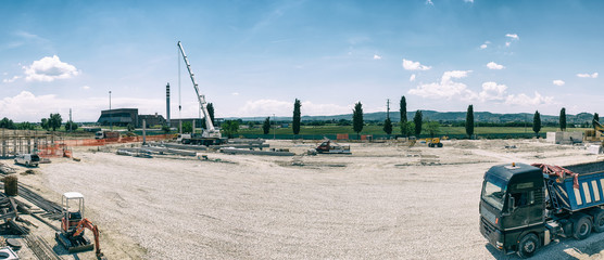 Landscape transformation into urban area with machinery, people working. View on construction site