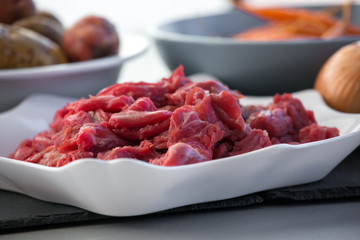 Raw beef meat on a white plate