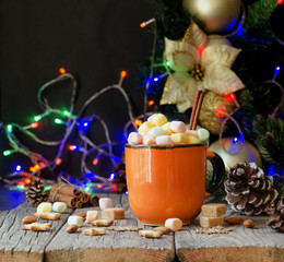 a cup of Christmas hot cocoa with marshmallow New Year's lights and decorations, selective focus