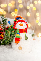 Christmas decoration on a wooden background with snowman and snow