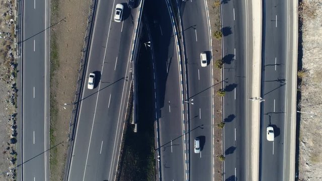 Aerovideo: unmanned aircraft flying over free interstate expressway with machines at autumn day. The modern architecture of curvy autoban, many different winding turn. Casual lifestyle in megapolis
